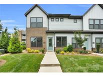 Charming two-story townhome with brick accents, a well-manicured lawn, and a welcoming turquoise front door at 5946 Ardrey Kell Rd, Charlotte, NC 28277