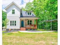 Charming two-story home featuring a covered porch, manicured lawn, and convenient carport at 600 S Cline Ave, Newton, NC 28658