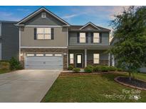 Charming two-story home boasts a stone and siding exterior with a well-manicured lawn at 687 Cape Fear St, Fort Mill, SC 29715