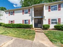 Charming condo with red shutters, well-maintained lawn, and easy access stairs to the front door at 7977 Shady Oak Trl, Charlotte, NC 28210