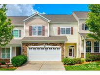 Inviting two-story townhouse featuring a stone facade and attached two-car garage at 809 River Park Rd, Belmont, NC 28012