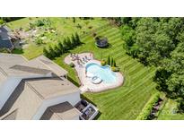 An inviting pool area features a stone patio, manicured lawn, fire pit, and multiple lounge chairs at 112 S Shore Dr, Belmont, NC 28012