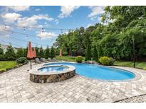 Backyard showcasing a pool, hot tub and lounge chairs under a bright blue sky at 112 S Shore Dr, Belmont, NC 28012