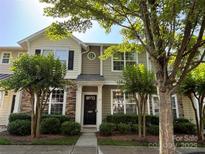 Inviting townhome with a wreath-adorned front door, manicured shrubs, and lovely stone and siding accents at 1139 Drummond Ln, Matthews, NC 28104