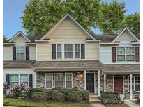 Charming townhome featuring stone accents, manicured landscaping, and a welcoming front porch at 117 Marakery Rd # B, Mooresville, NC 28115