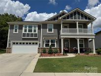 Charming two-story home with a landscaped yard, two-car garage, and inviting front porch at 1205 Aiken Cross Ln, Indian Trail, NC 28079