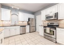 Bright kitchen features stainless steel appliances, ample white cabinetry, and neutral countertops at 14857 Santa Lucia Dr, Charlotte, NC 28277