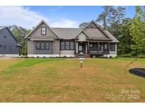 Stunning craftsman-style home with a combination of vertical siding and stone, showcasing its unique architectural details at 153 Mills Garden Rd, Statesville, NC 28625