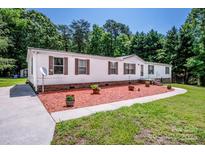Charming manufactured home featuring a well maintained yard, and warm curb appeal at 161 Crystal Bay Dr, Mooresville, NC 28115