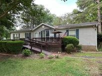 Charming single-story home with wood ramp, inviting front deck, and mature trees at 1925 Mt Hope Church Rd, Salisbury, NC 28146
