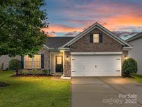 Charming brick home with attached two-car garage and a beautiful sunset backdrop at 2005 Grimley Ln, Fort Mill, SC 29707