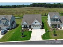 Charming single-Gathering home with a well-manicured lawn and an inviting front entrance with an attached two-car garage at 2048 Turnsberry Dr, Monroe, NC 28112