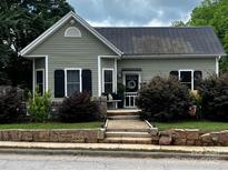 Charming home with new roof, stone accents, updated landscaping, and a cozy front porch at 303 N Main N St, Granite Quarry, NC 28146
