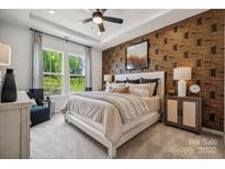This main bedroom features a decorative accent wall and large windows with view of nature at 3117 Beacon Heights Rd, Indian Land, SC 29707