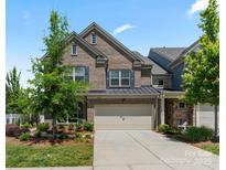 Charming two-story brick home with a well-manicured lawn and attached two-car garage at 4028 Woodsmill Rd, Fort Mill, SC 29707