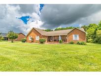 Charming brick home featuring a well-manicured lawn and inviting front porch at 4470 W Bandys Cross Rd, Claremont, NC 28610