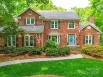 Charming two-story brick home with a well-manicured lawn and a welcoming blue front door at 5900 Colwick Nw Ct, Concord, NC 28027