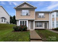 Charming two-story townhome featuring beige siding, a well-maintained lawn, and a welcoming front entrance at 6121 Dane Dr, Dallas, NC 28034