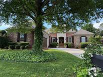 Charming brick home with a well-manicured lawn, mature trees, and a welcoming front entrance at 705 Woburn Abbey Dr, Fort Mill, SC 29715