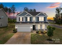 Charming two-story home with a two-car garage, manicured lawn, and beautiful landscaping at 7604 Tanglewood Way, Denver, NC 28037