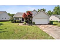 Charming single-story home with well-manicured lawn, lovely landscaping and an attached two-car garage at 8105 Castlemaine Dr, Matthews, NC 28104