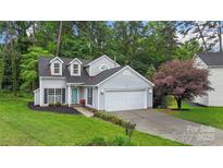 Charming two-story home with a well-manicured lawn, an attached garage, and tasteful landscaping at 8302 Holbrook Square Ct, Charlotte, NC 28216