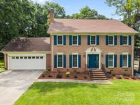 Charming brick two-story home with well-manicured lawn and attached two car garage at 9001 Peyton Randolph Dr, Charlotte, NC 28277