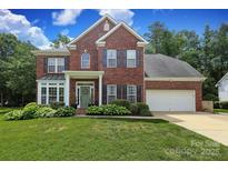 Beautiful two-story brick home with a well-manicured lawn and attached two car garage at 916 Cadogan Ct, Fort Mill, SC 29708