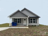 Charming single-story home with gray siding, a covered porch, and neatly landscaped front yard at 003 West Ave, Wadesboro, NC 28170