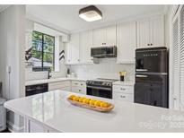 Bright kitchen featuring white cabinets, modern appliances, quartz countertops, and a black Galanz refrigerator at 1121 Myrtle Ave # 72, Charlotte, NC 28203