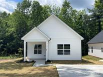 Charming one-story home with white siding, a covered porch, and a well-manicured lawn at 1312 7Th St, Statesville, NC 28677