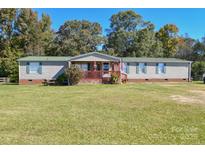 Charming single-story home with a green roof, front porch, and expansive front yard at 1574 Burke Duncan Rd, Lancaster, SC 29720