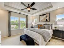 A bright main bedroom features large windows, tray ceiling and ensuite bathroom at 316 Catawba Ave, Davidson, NC 28036