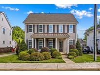 Charming two-story home featuring a covered front porch and manicured landscaping at 376 Delburg St, Davidson, NC 28036