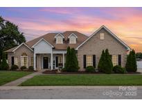 Charming brick home with a manicured lawn, complemented by beautiful landscaping and a welcoming facade at 4406 Atkinson Way, Monroe, NC 28110