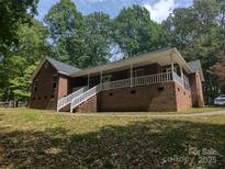 Charming brick home featuring a welcoming front porch with white railings and stairs at 4620 Binwhe Ln, Gastonia, NC 28052