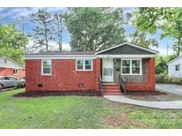 Charming brick home featuring a neatly landscaped front yard and inviting entryway, showcasing classic design and curb appeal at 4913 Winchester St, Charlotte, NC 28208