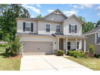 Charming two-story home with a two-car garage, manicured lawn, and inviting front porch with supporting columns at 941 Rachel Anne Dr, Belmont, NC 28012