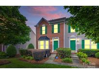 Charming brick townhome with green door and shutters, manicured landscaping at 9775 Mallard Glen Dr, Charlotte, NC 28262