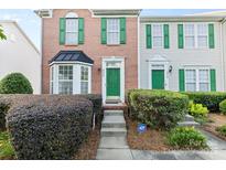 Charming townhome with a brick facade, green shutters, and a well-maintained front yard at 9775 Mallard Glen Dr, Charlotte, NC 28262