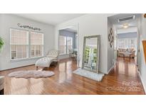Sunlit living room with hardwood floors, neutral walls, and a view into the dining area at 9775 Mallard Glen Dr, Charlotte, NC 28262
