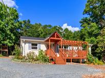 Charming home with a wooden pergola deck and a gravel driveway surrounded by lush trees at 10743 Ola Dr, Fort Mill, SC 29707