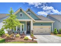 Charming, light green single-Gathering home with stone accents, a two-car garage and a welcoming front porch at 1133 Idyllic Ln, Waxhaw, NC 28173