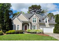 Charming home featuring a stone facade, arched entryway, manicured landscaping, and a two-car garage at 1253 Iverleigh Trl, Charlotte, NC 28270