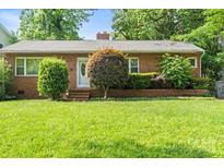 Charming single-story brick home with a well-manicured lawn and mature landscaping at 1315 Cortland E Rd, Charlotte, NC 28209