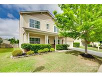 Inviting two-story home with a well-manicured lawn and charming covered front porch at 1412 Afternoon Sun Rd, Matthews, NC 28104