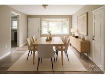Bright dining room featuring a wooden table, beige chairs, and large windows providing ample natural light at 1421 Thompson Ave, Charlotte, NC 28216