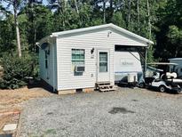 Quaint one-story home with white siding, complemented by an adjacent RV and golf cart at 146 Larboard Trl, Mount Gilead, NC 27306