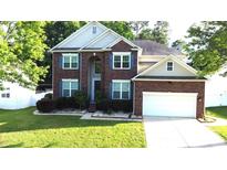 Charming two-story brick home with manicured lawn and attached two-car garage, located on a tree-lined street at 14615 Bridle Trace Ln, Pineville, NC 28134