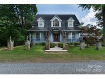 Charming two-story home featuring a well-manicured lawn and unique stone archway leading to the front door at 150 8Th Ave, New London, NC 28127